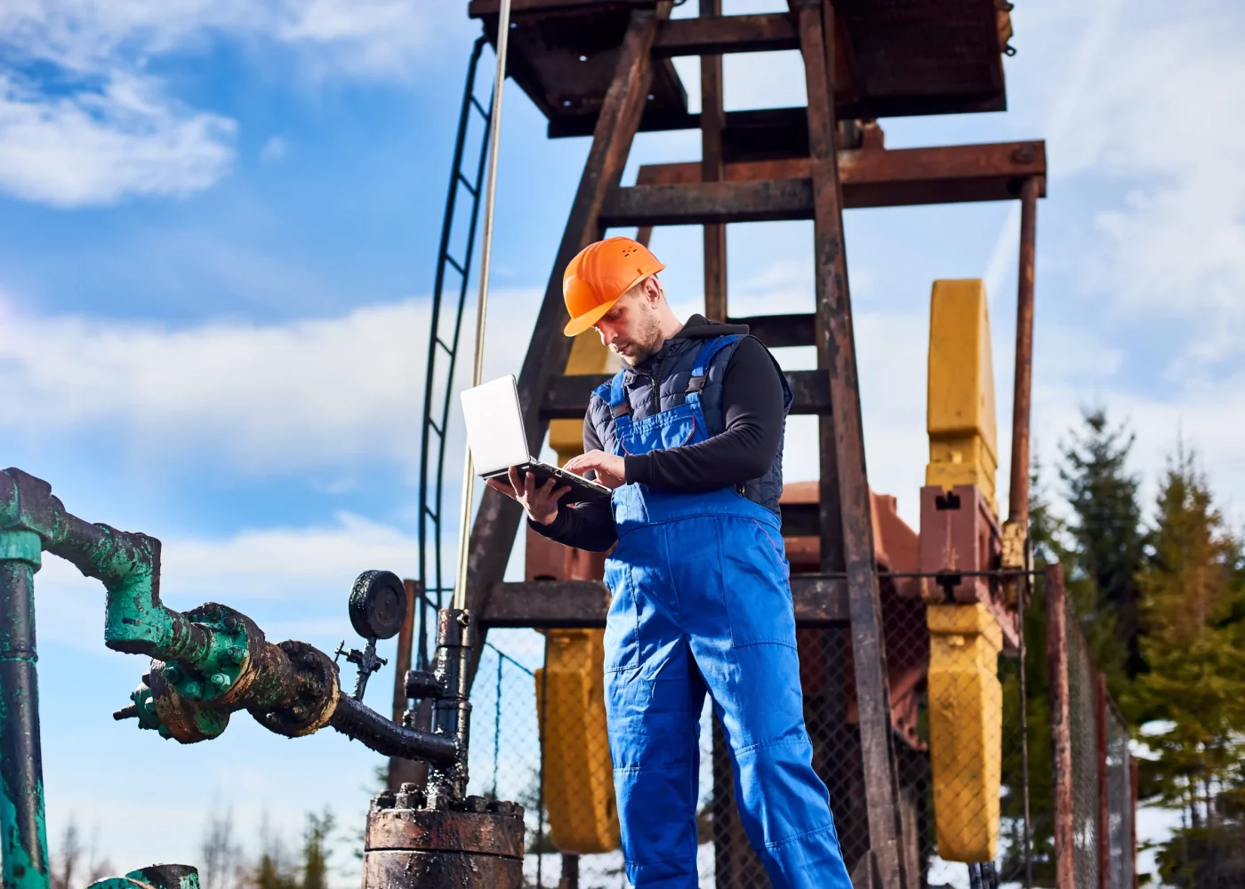 petroleum-engineer-using-laptop-oil-field